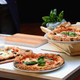 three neapolitan pizzas on a table
